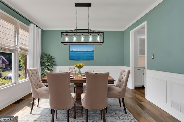 dining area featuring dark wood-type flooring and ornamental molding