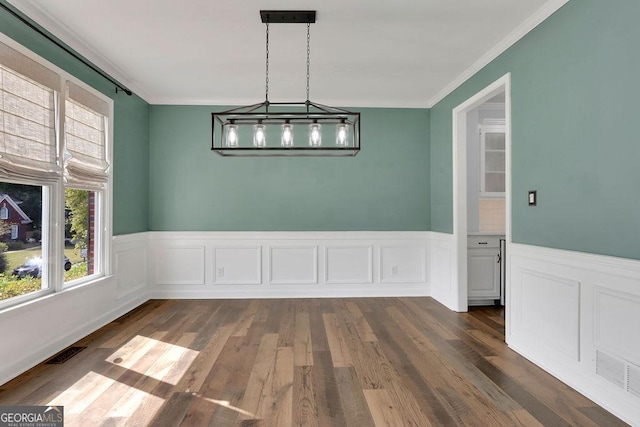 unfurnished dining area with crown molding and dark wood-type flooring