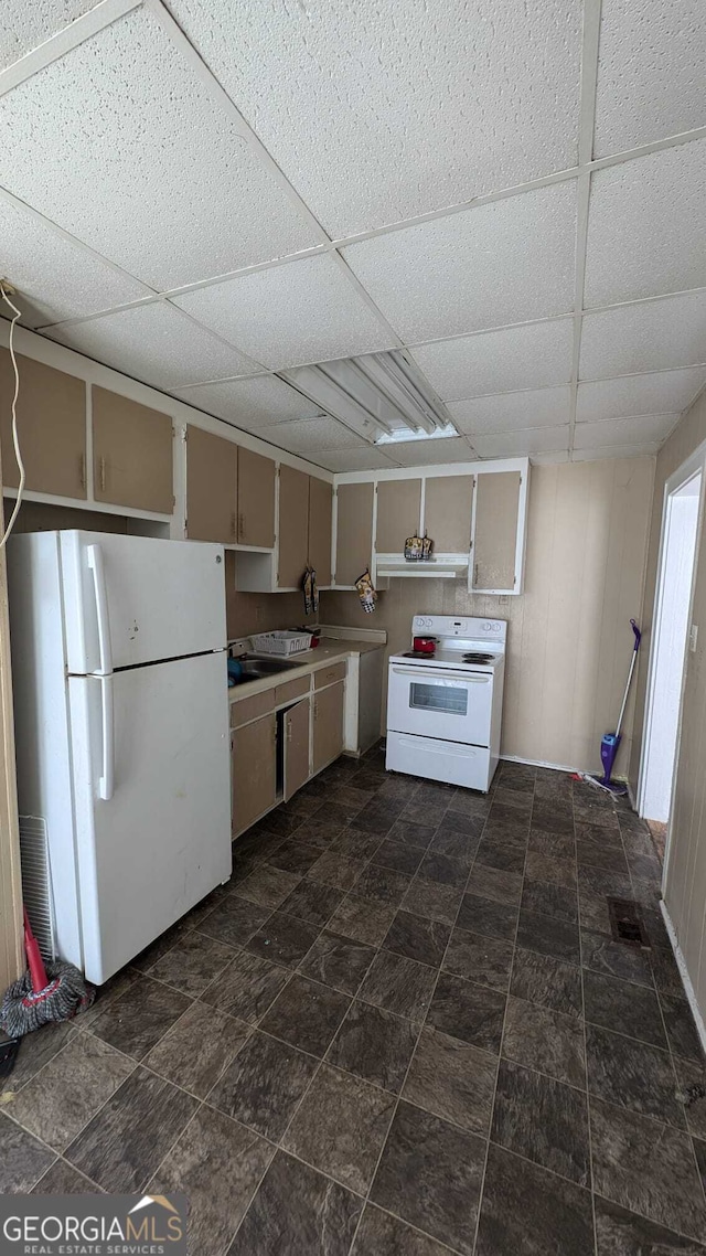 kitchen featuring cream cabinets, a paneled ceiling, and white appliances