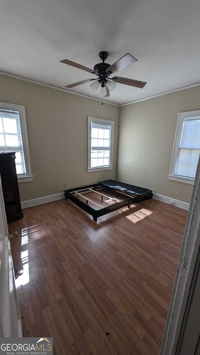spare room with crown molding, dark hardwood / wood-style flooring, and ceiling fan