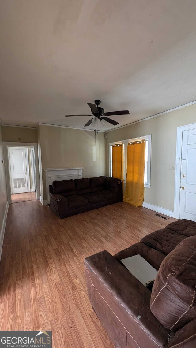 unfurnished living room with ornamental molding, light hardwood / wood-style flooring, and ceiling fan