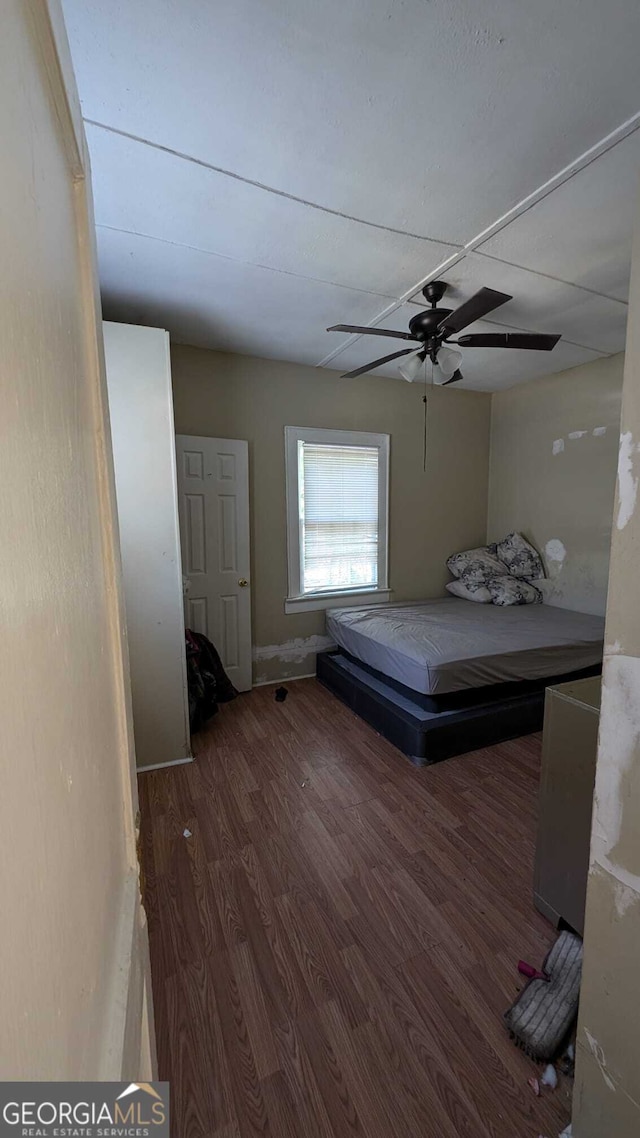 unfurnished bedroom featuring dark wood-type flooring and ceiling fan