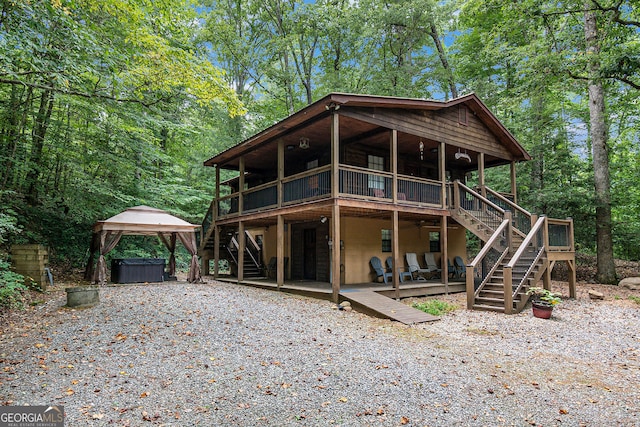 rear view of property with a wooden deck and a gazebo