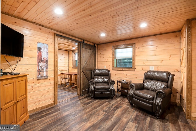 living area featuring a barn door, wooden ceiling, wood walls, and dark wood-type flooring
