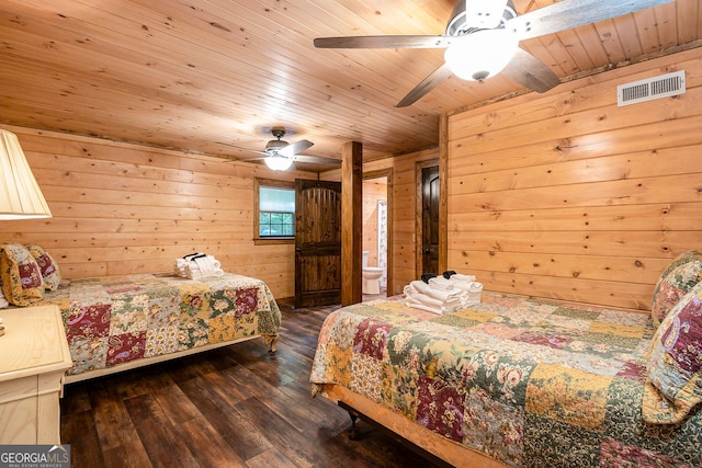 bedroom featuring dark wood-style flooring, visible vents, wood walls, ceiling fan, and wood ceiling