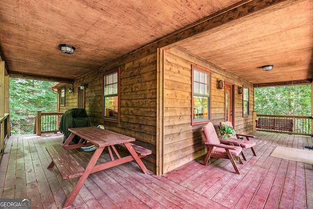 wooden deck with area for grilling and a porch