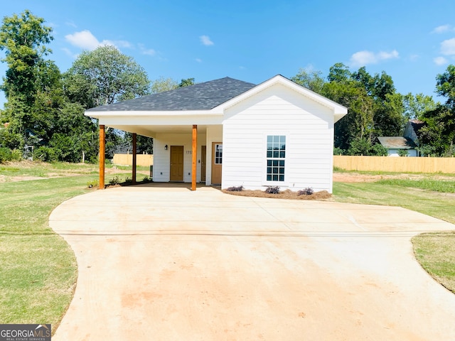 view of front of home with a front yard and a carport