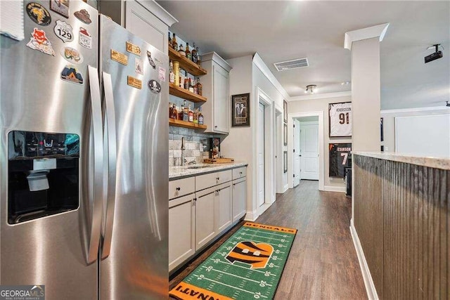 kitchen featuring light stone countertops, sink, tasteful backsplash, stainless steel fridge with ice dispenser, and dark hardwood / wood-style flooring