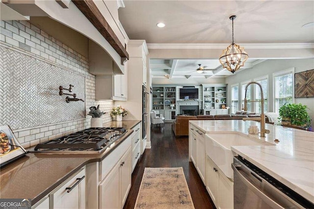 kitchen featuring dark hardwood / wood-style flooring, stainless steel appliances, sink, decorative light fixtures, and dark stone countertops