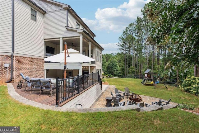 view of yard with a playground, a patio area, and an outdoor living space with a fire pit