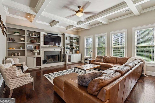 living room featuring a healthy amount of sunlight, dark wood-type flooring, and coffered ceiling