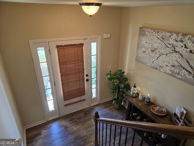 foyer entrance with dark wood-type flooring and baseboards