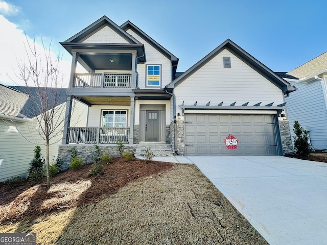 view of front of house featuring a garage, covered porch, and a balcony