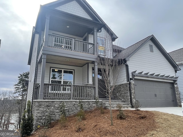 view of front of home with a garage, a balcony, and a porch