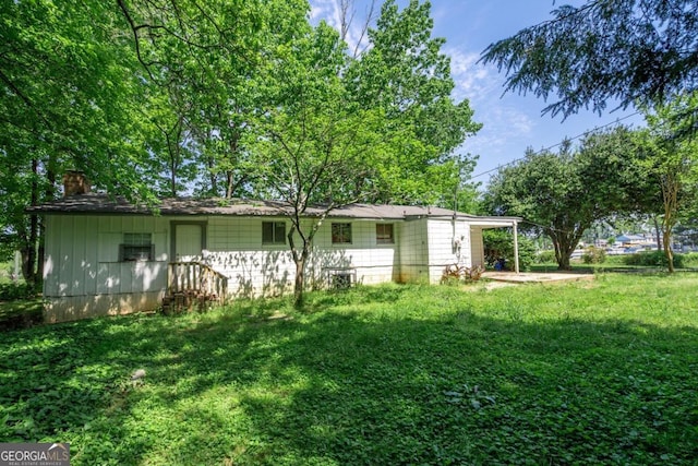 rear view of property with a lawn