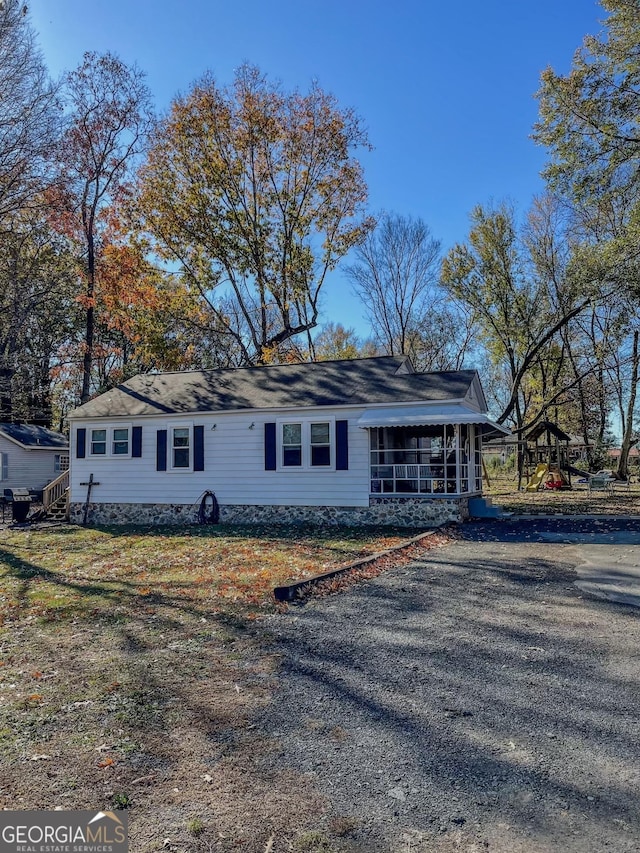 single story home with a front yard and a storage unit