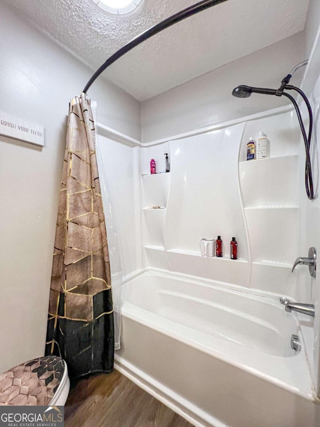 bathroom featuring a textured ceiling, hardwood / wood-style flooring, and shower / bathtub combination with curtain