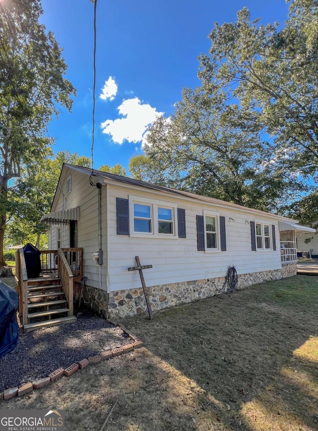 view of front of house with a wooden deck and a front lawn