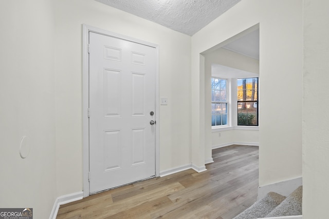 entryway featuring a textured ceiling and light hardwood / wood-style flooring