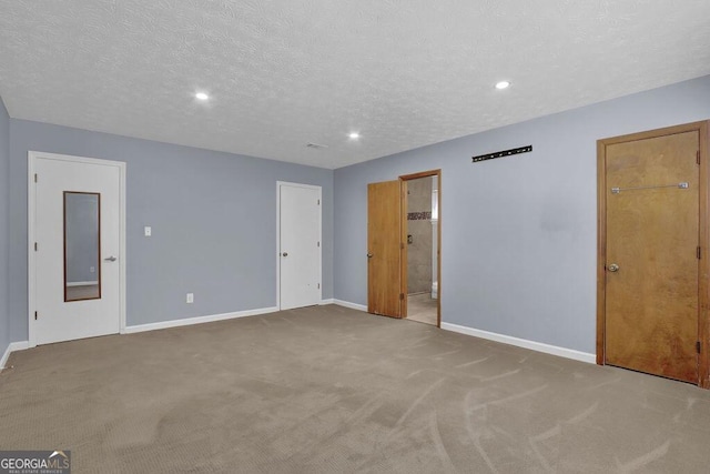 carpeted spare room with a textured ceiling