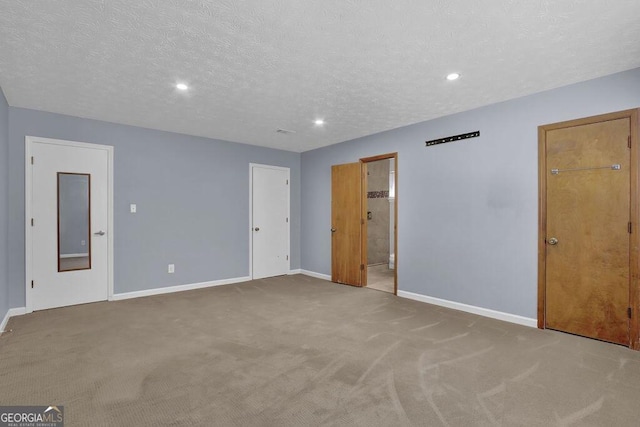 unfurnished bedroom featuring carpet, connected bathroom, a textured ceiling, recessed lighting, and baseboards