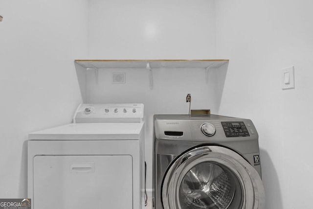 clothes washing area with washer and clothes dryer