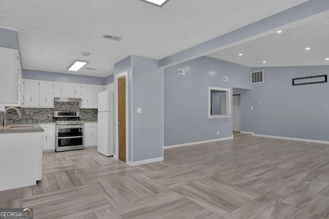 kitchen featuring a sink, visible vents, double oven range, and freestanding refrigerator