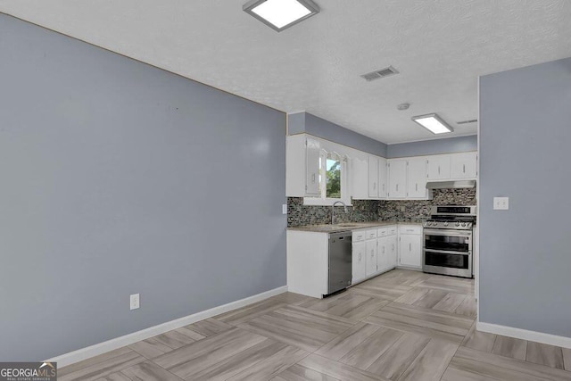kitchen featuring visible vents, white cabinets, baseboards, appliances with stainless steel finishes, and backsplash