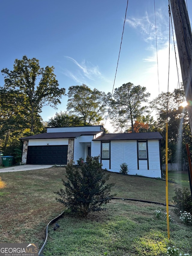 mid-century inspired home with an attached garage, a front yard, and stone siding