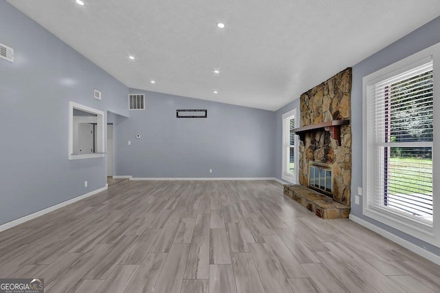 unfurnished living room featuring light wood-type flooring, baseboards, vaulted ceiling, and visible vents
