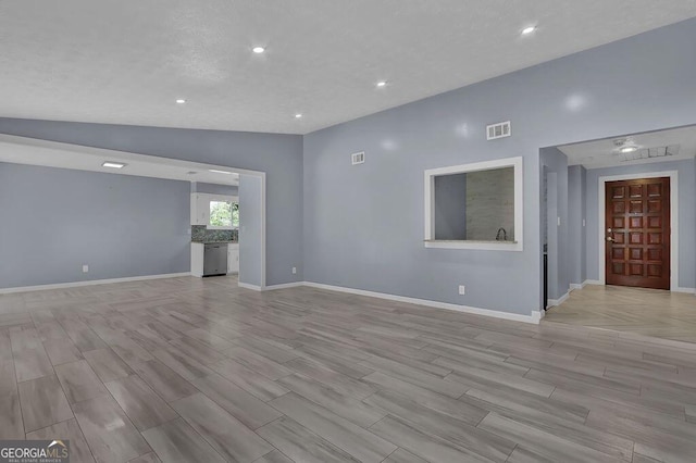 unfurnished room with visible vents, baseboards, and vaulted ceiling