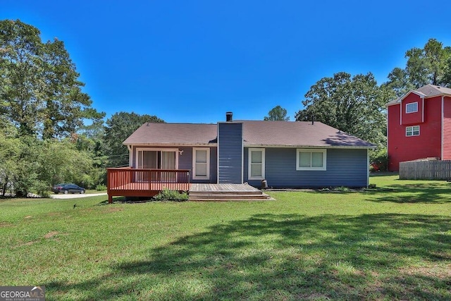 rear view of house with a lawn and a deck