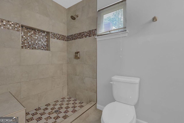 bathroom with tiled shower and toilet