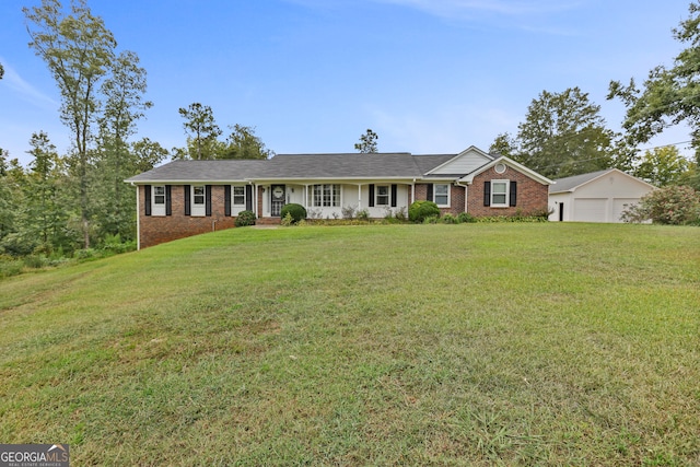 ranch-style home with a garage, a front yard, and an outbuilding