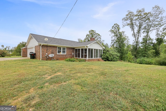 view of front of house featuring a front yard, a garage, and a sunroom