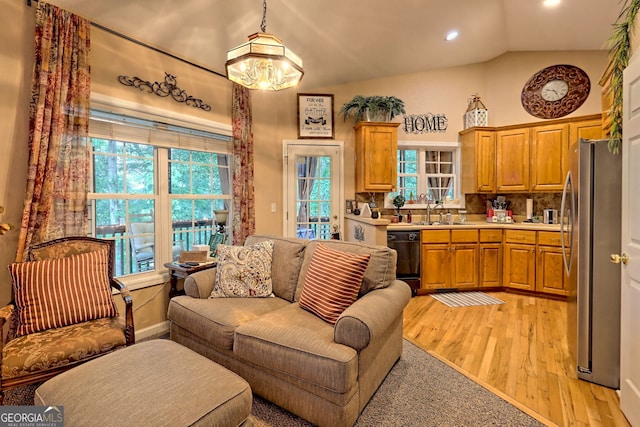 living room with lofted ceiling, light wood-type flooring, and sink