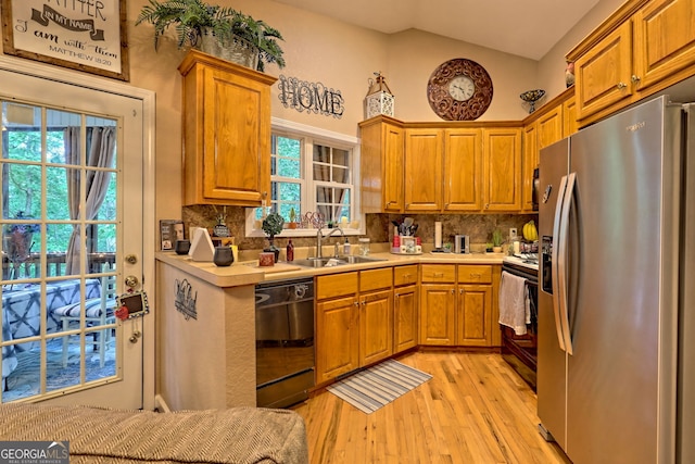 kitchen with decorative backsplash, stainless steel appliances, light hardwood / wood-style flooring, and sink