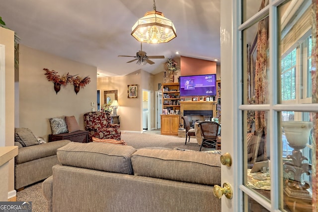 carpeted living room with ceiling fan and lofted ceiling