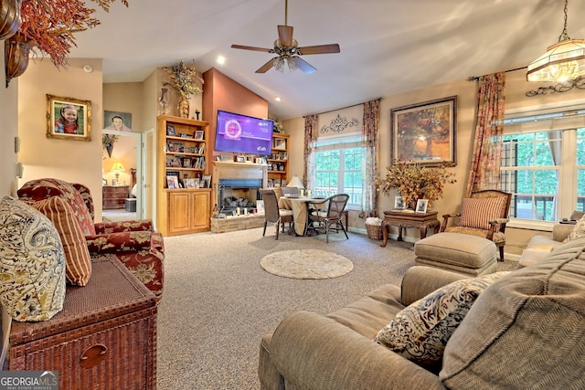 carpeted living room with ceiling fan and lofted ceiling