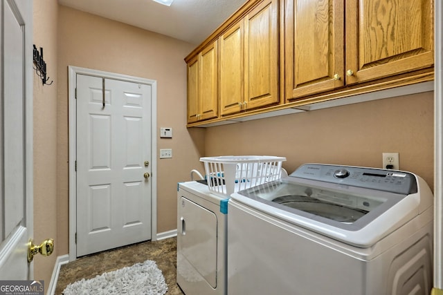 laundry room featuring washing machine and clothes dryer and cabinets