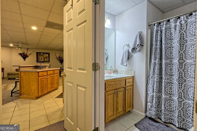 bathroom with tile patterned flooring, vanity, and a paneled ceiling