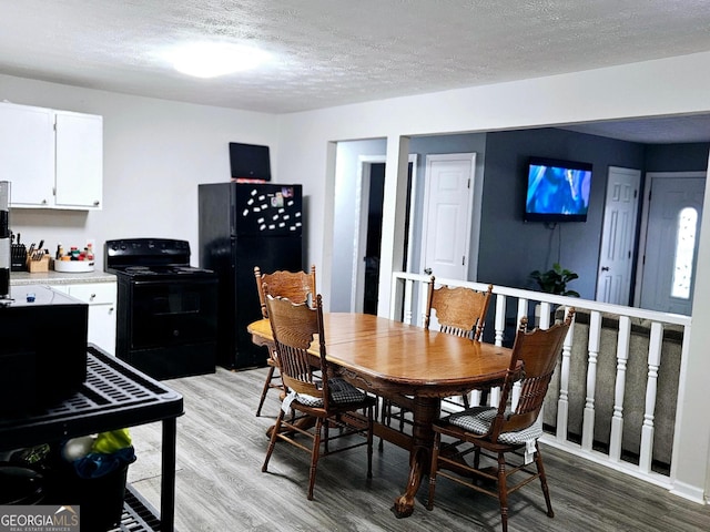 dining space with a textured ceiling and light hardwood / wood-style floors