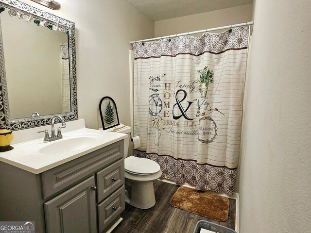 bathroom featuring vanity, toilet, hardwood / wood-style floors, and a shower with shower curtain