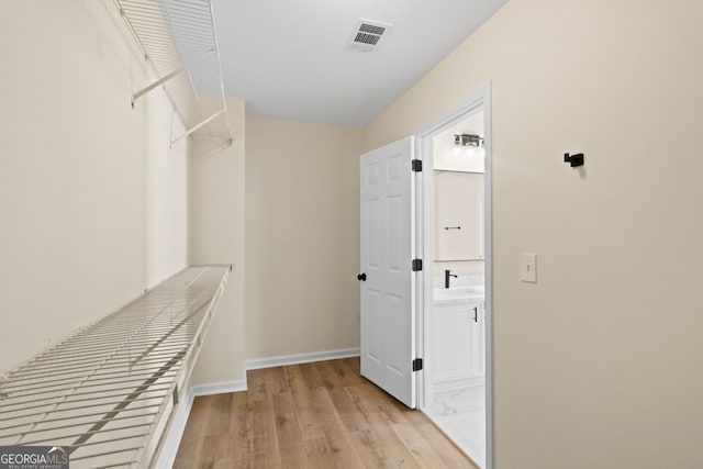 spacious closet with light wood-type flooring and visible vents