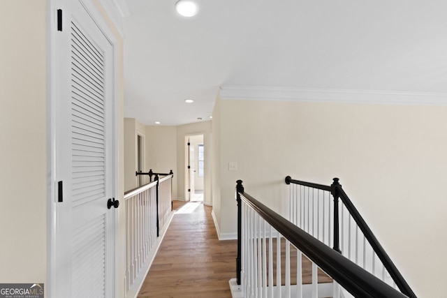 corridor with recessed lighting, crown molding, an upstairs landing, and wood finished floors