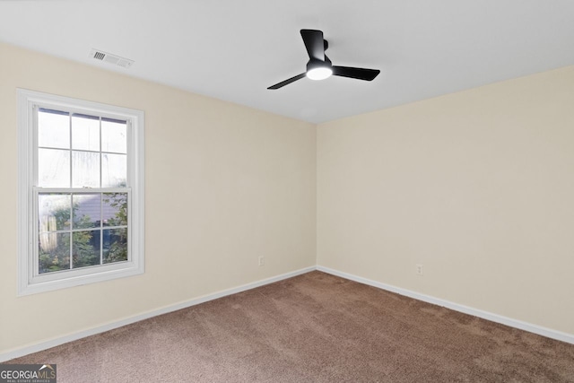 spare room with a ceiling fan, carpet, visible vents, and baseboards