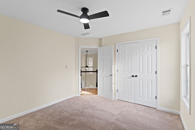 unfurnished bedroom with carpet floors, visible vents, and baseboards