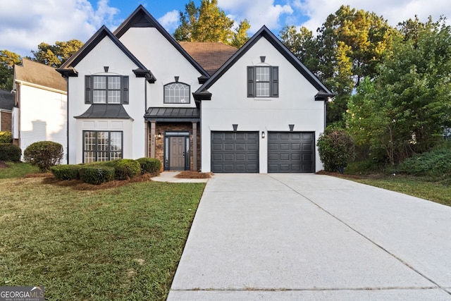 french provincial home featuring metal roof, an attached garage, concrete driveway, a standing seam roof, and a front yard