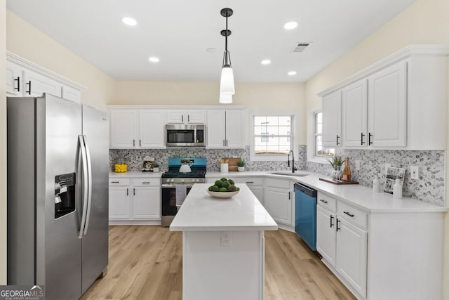 kitchen featuring stainless steel appliances, a sink, and white cabinetry