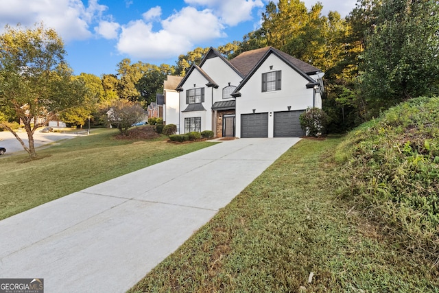 view of front facade with a garage, concrete driveway, stucco siding, a standing seam roof, and a front yard